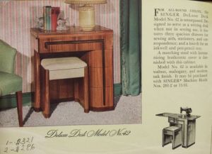 An old magazine advertisement for the Singer Deluxe Desk Model No. 42 wooden art deco-style sewing machine cabinet.